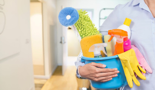Person carrying bucket of cleaning supplies